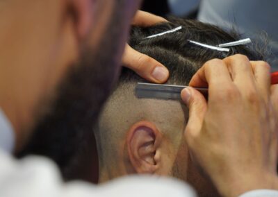 A barber uses a razor for precise grooming during a haircut in a modern barbershop.