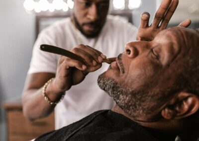 Close-up of a barber using a straight razor for precise grooming.